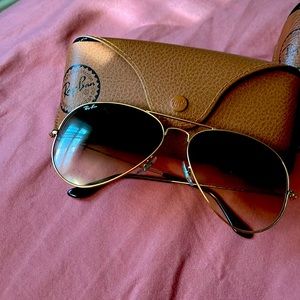 2 pair of Ray-Ban sunglasses. One gold frame aviator and one deep red cat eye.